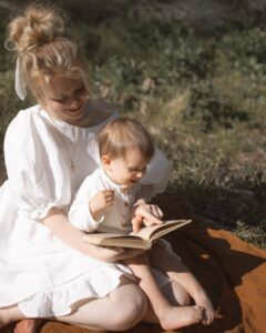 photo of woman and baby reading a book